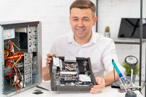 computer repair shop. professional services. a man repairs motherboard