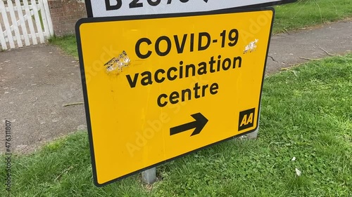 Covid-19 Vaccination Centre,  Yellow road sign directing to  Covid-19 Vaccination centre. stock footage video photo