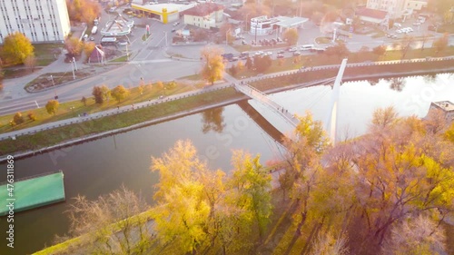 Pedestrian bridge across the river Kharkiv (Mist Zakokhanykh), favorite place of couples. Bright autumnal aerial treetop view on colorful Kharkiv, travel Ukraine photo