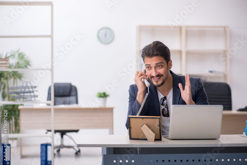 Young handsome employee working in the office