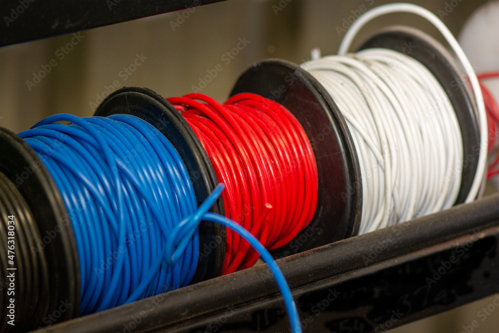 Electrical cable rolls in the  colours of red white and blue. 