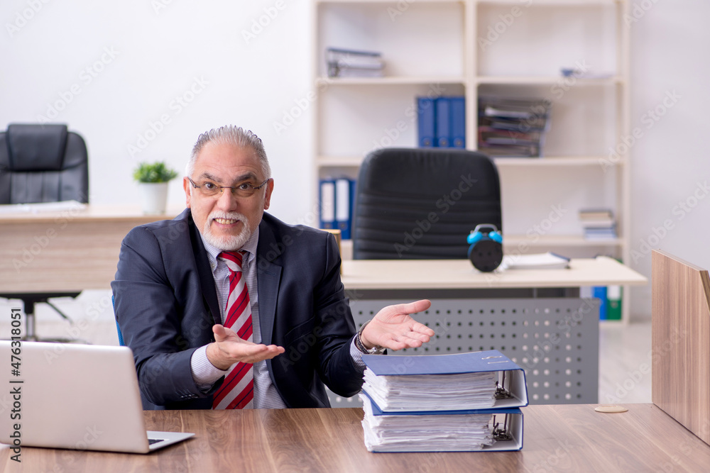 Old male employee working in the office Old male employee working in the office
