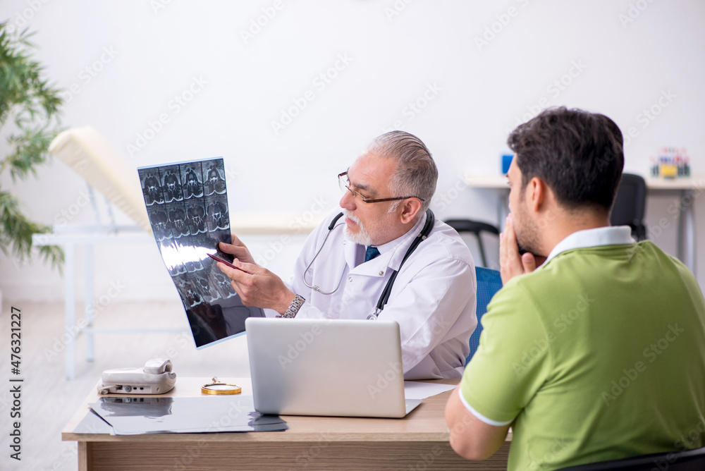 Young man visiting old male doctor radiologist Young man visiting old male doctor radiologist
