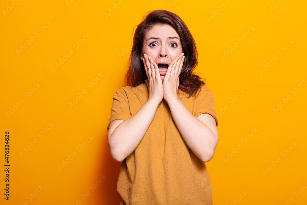 Portrait of terrified person holding hands on face to pose on camera. Scared woman screaming and being afraid, having anxious expression in studio. Frightened adult with emotions Portrait of terrified person holding hands on face to pose on camera. Scared woman screaming and being afraid, having anxious expression in studio. Frightened adult with emotions