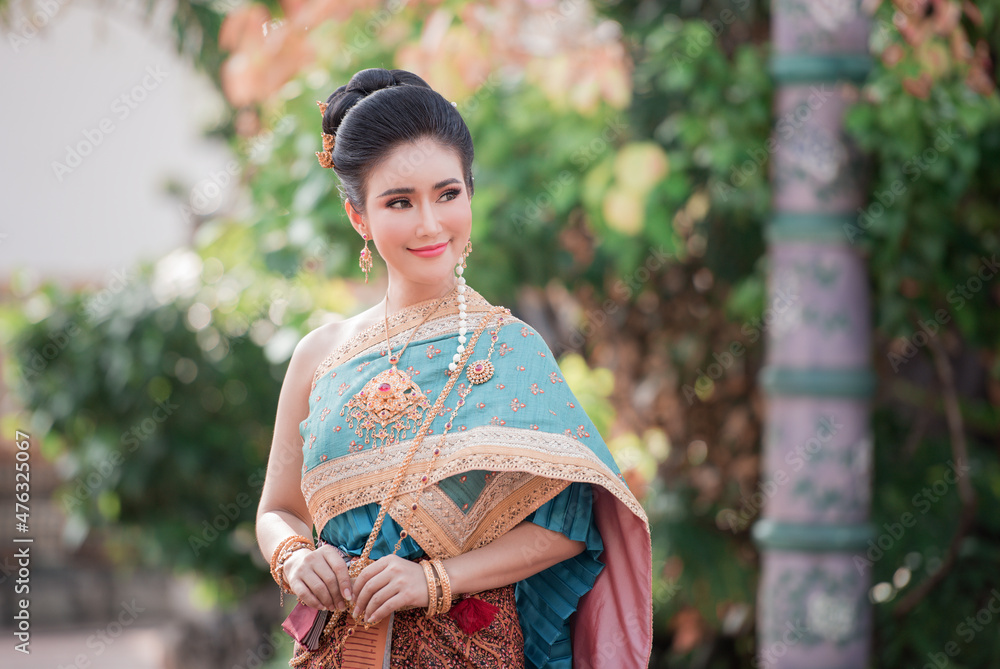Portrait of a beautiful woman wearing a traditional Thai dress smiling gracefully standing in a temple of Thailand Portrait of a beautiful woman wearing a traditional Thai dress smiling gracefully standing in a temple of Thailand