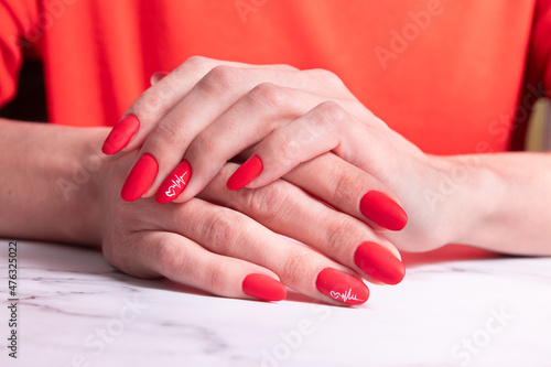 Red matte manicure on female hands for valentines day