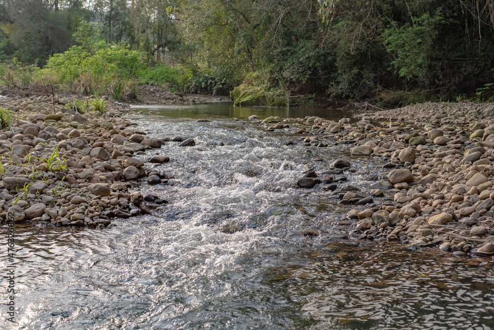 water flowing through pebbles in stream water flowing through pebbles in stream