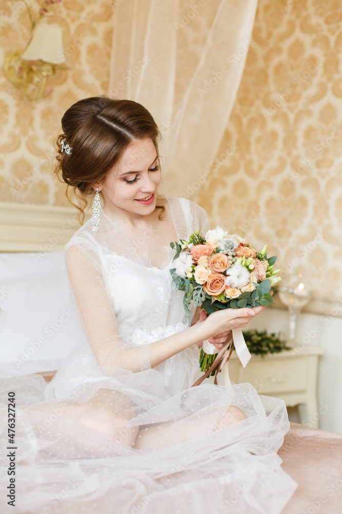 Pretty young Bride.Brown-haired woman with classic wedding hair-style. Boudoir morning of the bride. Taking a little candle in her hands Pretty young Bride.Brown-haired woman with classic wedding hair-style. Boudoir morning of the bride. Taking a little candle in her hands