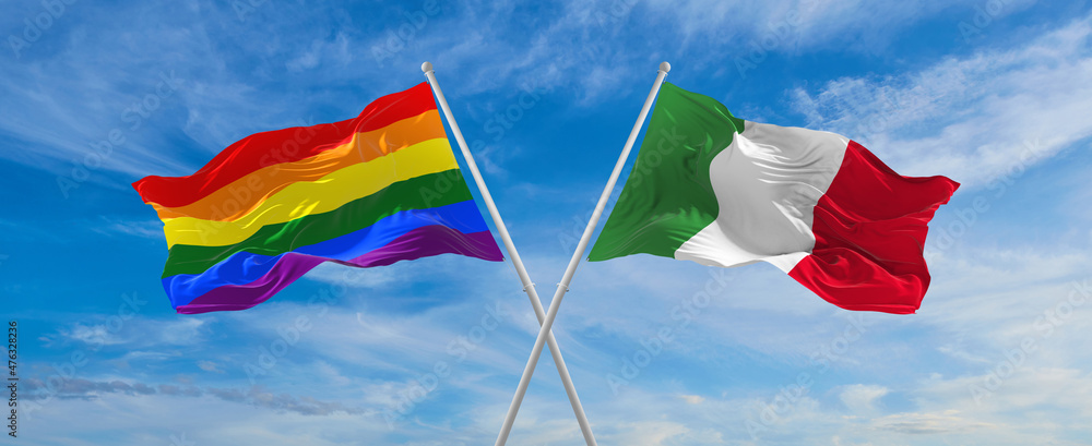 crossed flags of lgbt and Italia flag waving in the wind at cloudy sky ...