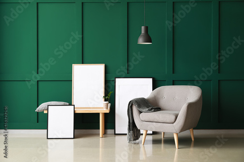 Interior of stylish room with armchair and blank frames