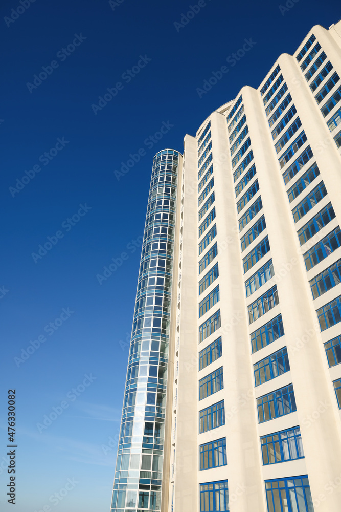 Beautiful skyscraper against blue sky on sunny day, low angle view