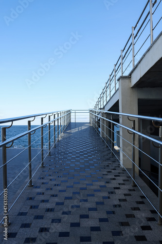 Modern terrace with metal railings and stairs near sea