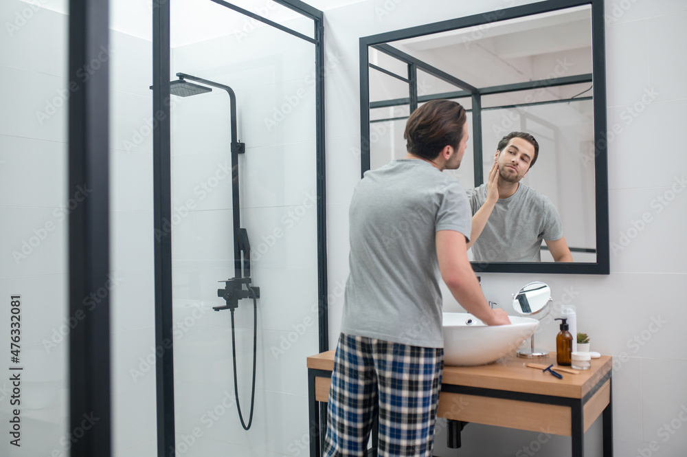 Obraz premium Man near the mirror scrutinizing himself