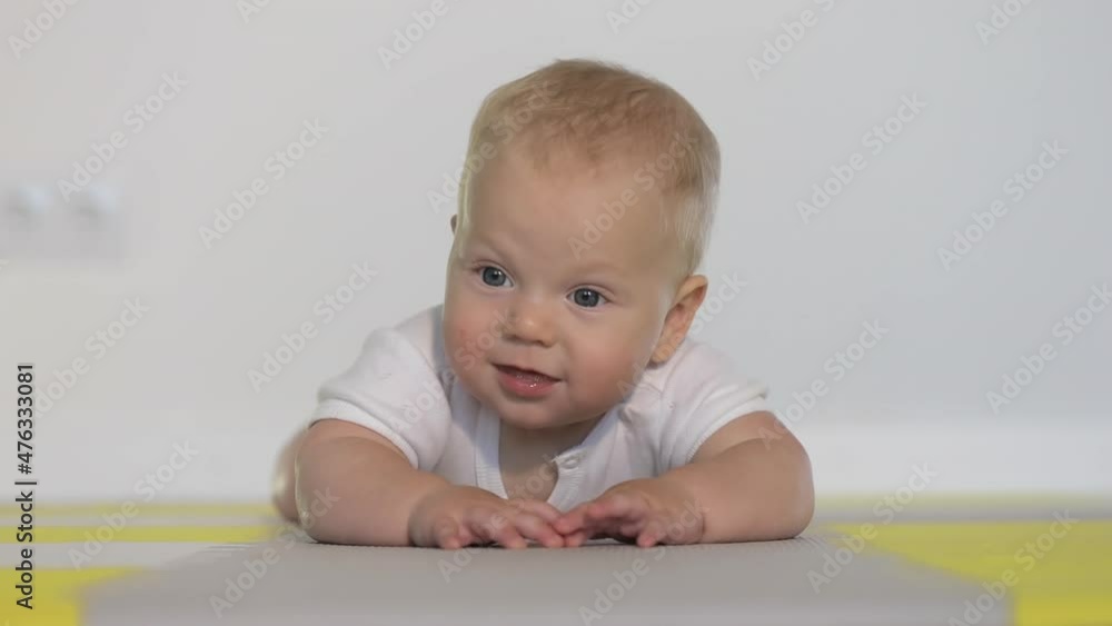 The baby begins to learn to crawl on the floor The baby begins to learn to crawl on the floor