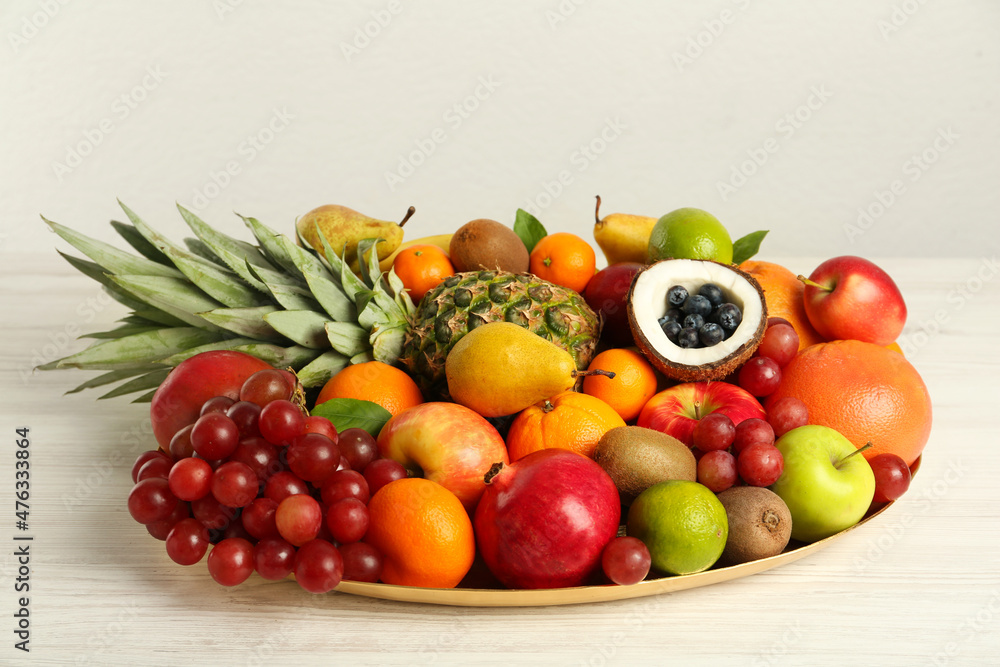 Platter with different fresh fruits on white wooden table Platter with different fresh fruits on white wooden table