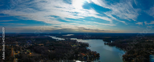 a stunning aerial panoramic shot of the silky green Catawba River surrounded by vast miles of green and autumn colored trees with blue sky and powerful clouds at sunset in Charlotte North Carolina photo