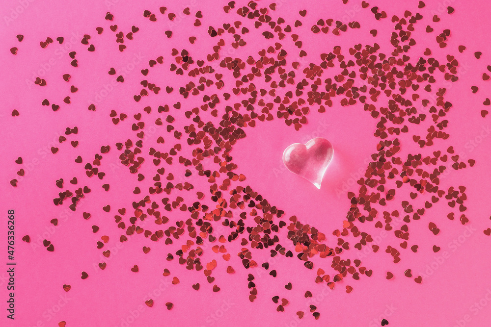 A figurine of a glass heart on an abstract background of many small hearts. The concept of Valentine's Day.