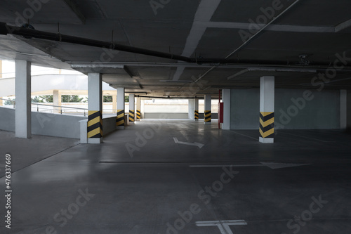 Empty open car parking garage with warning stripes on columns
