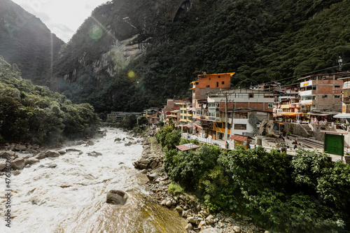 Fast paced Urubamba river flows past a town, Cusco, Peru photo