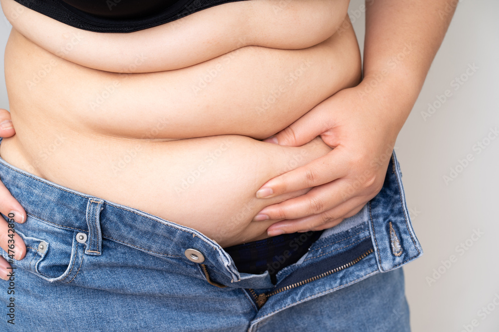 Fototapeta premium Overweight women hand touch big belly