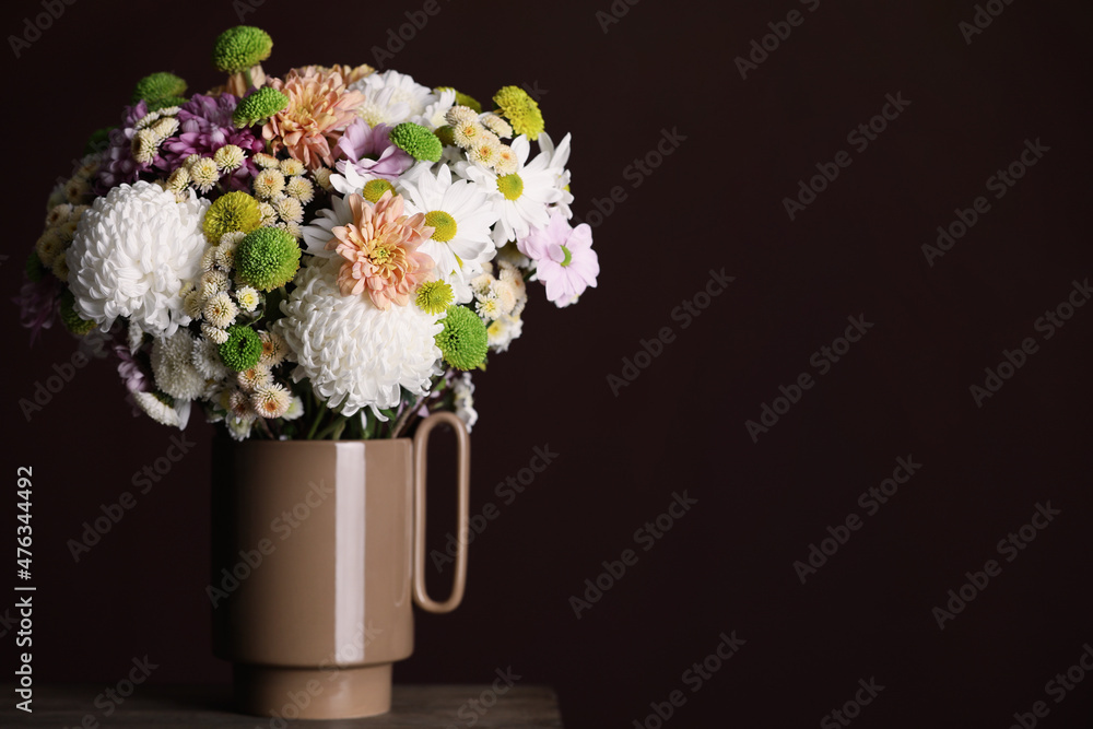 Fototapeta premium Bouquet of beautiful chrysanthemum flowers on table against dark background, space for text