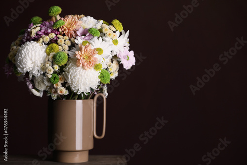 Bouquet of beautiful chrysanthemum flowers on table against dark background, space for text