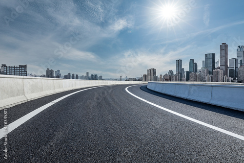 Empty asphalt road and city skyline with modern commercial buildings © ABCDstock