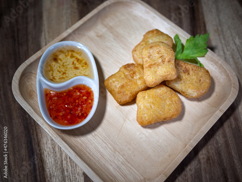 Chicken nuggets with sauces on wooden table.