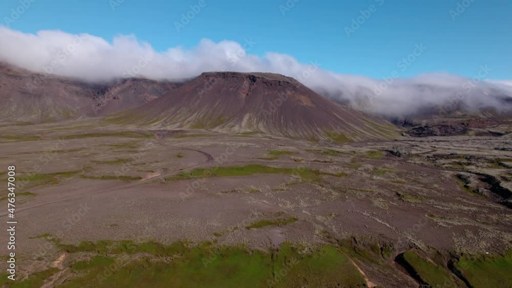 Aerial shot approaching a mountain with fog in Iceland. Barren landscape below, dormant volcano. Aerial shot approaching a mountain with fog in Iceland. Barren landscape below, dormant volcano.