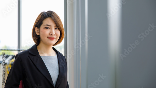 Portrait close up studio shot of Asian young happy short hair female cheerful millennial businesswoman blogger vlogger freelancer influencer in formal suit smiling look at camera in office building Free Download Portrait close up studio shot of Asian young happy short hair female cheerful millennial businesswoman blogger vlogger freelancer influencer in formal suit smiling look at camera in office building - GFXLoad