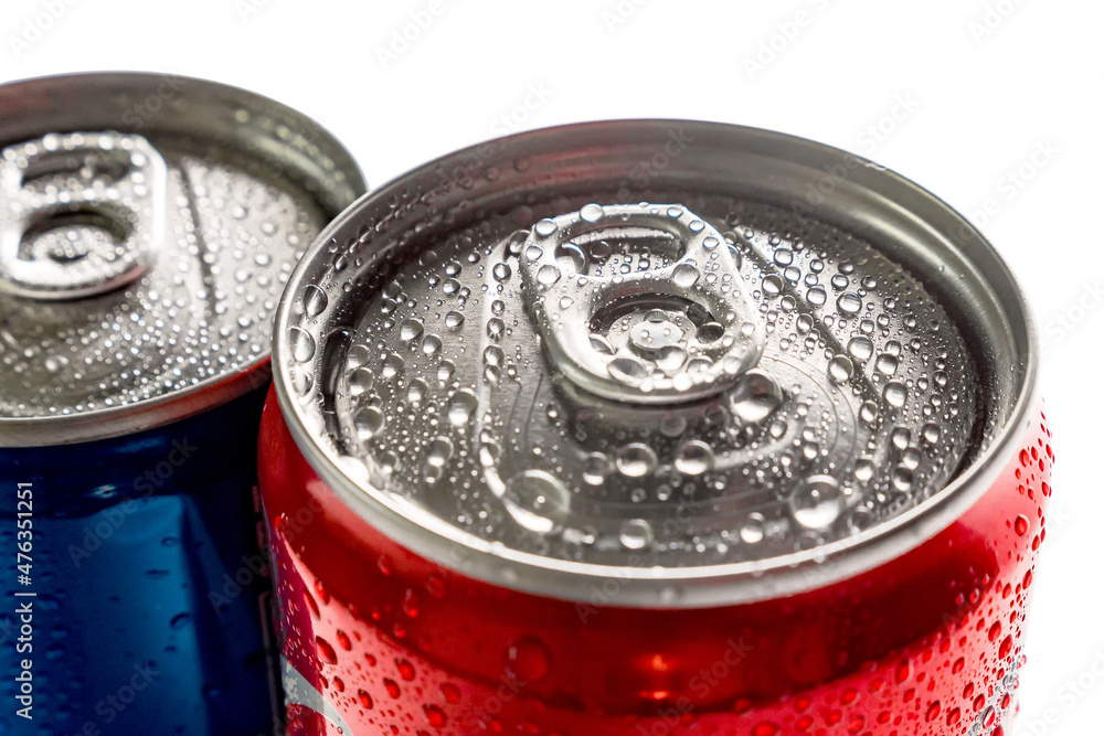 Close-up of a blue and red can of sweet drinks on a white background. Water droplets on the surface of the metal. Top view. Close-up of a blue and red can of sweet drinks on a white background. Water droplets on the surface of the metal. Top view.