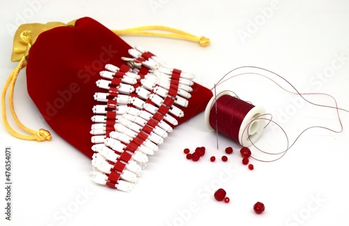 Handmade jewelry made of square beads, red threads and a red bag