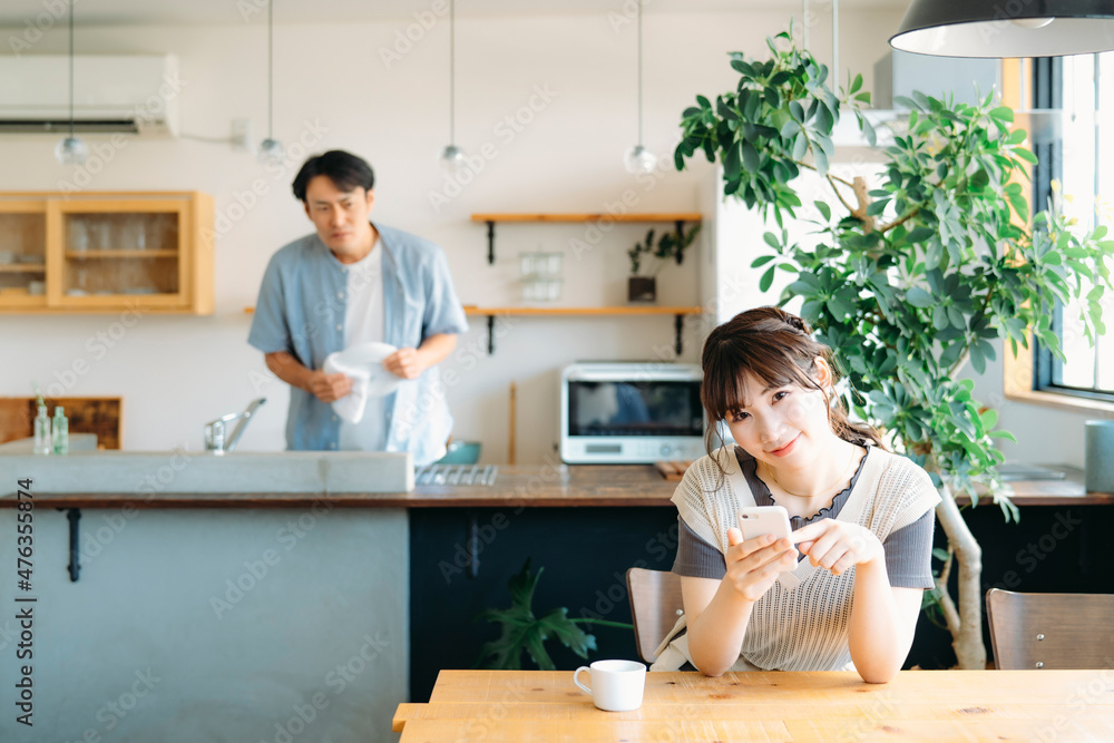スマホを見る女性と疑う男性(笑顔)
スマホを見る女性と疑う男性(笑顔)