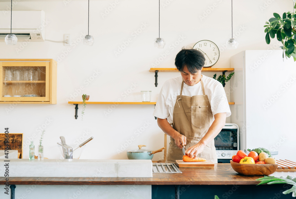 キッチンに立つ男性(野菜を切る)
キッチンに立つ男性(野菜を切る)