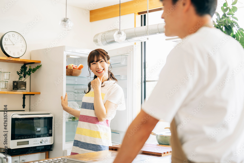 Fototapeta premium 冷蔵庫の前に立つ女性と男性 