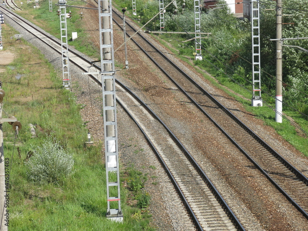 suburban railway tracks with poles and rails in summer suburban railway tracks with poles and rails in summer