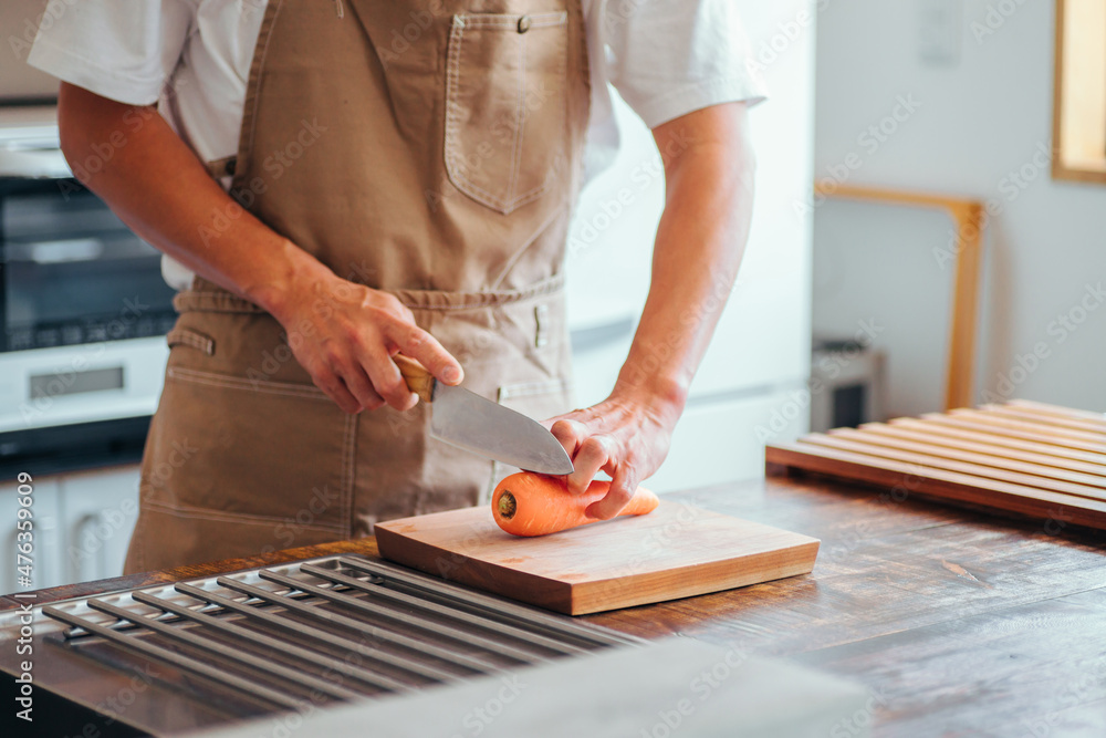 Obraz premium キッチンに立つ男性（野菜を切る） 