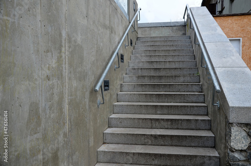 wheelchair ramp and stairs on the other side. height differences are tastefully and functionally solved by a retaining wall with a glass railing. city ​​stairs with recessed lights  park waterfront 