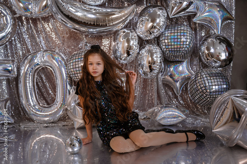 cute little child girl in black dress on confetti background