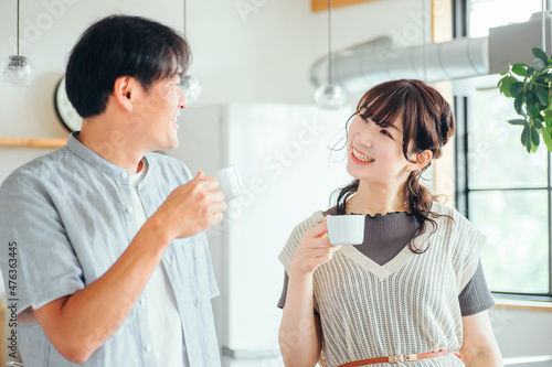 キッチンの前でコーヒーを飲む男女（夫婦）
