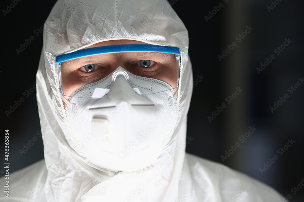 Male lab worker in protective respirator and white coverall, smart scientist Male lab worker in protective respirator and white coverall, smart scientist