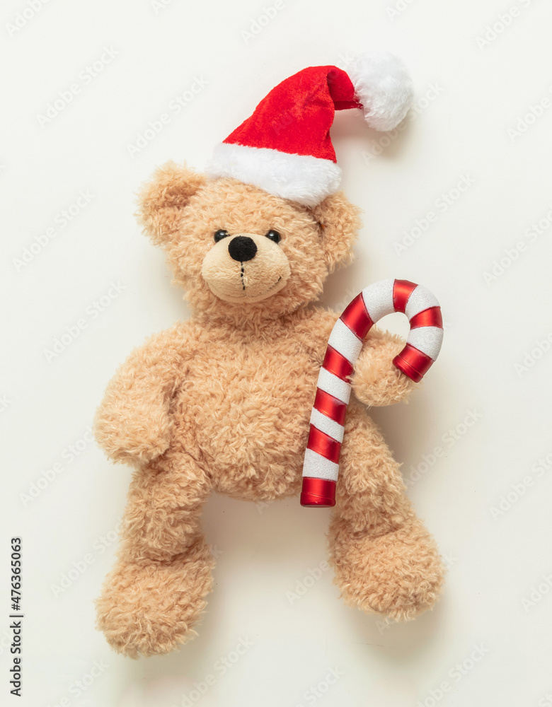 Christmas present. Teddy bear wearing a Santa hat on white background, Holiday greeting card. Christmas present. Teddy bear wearing a Santa hat on white background, Holiday greeting card.