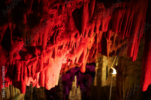 red abstract background of stalactites, stalagmites and stalagnates in a cave underground, horizontal