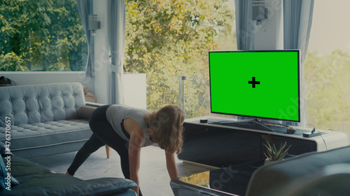 GIrl exercise in living room infront of TV with Mock up Green screen
