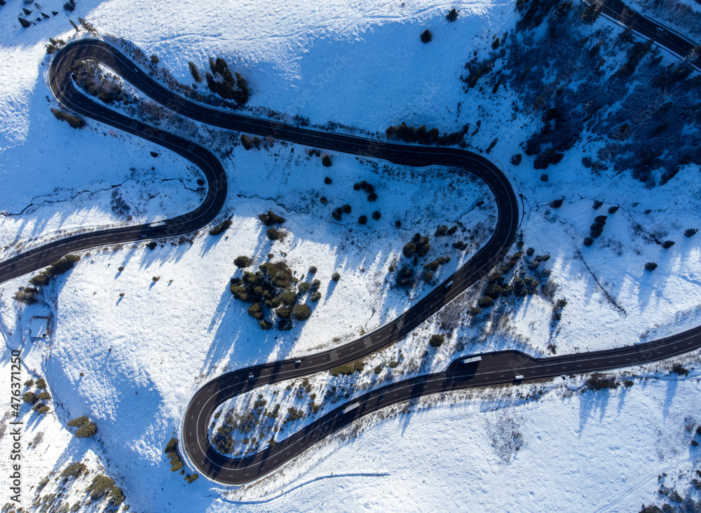 a winding road in the snow seen from above