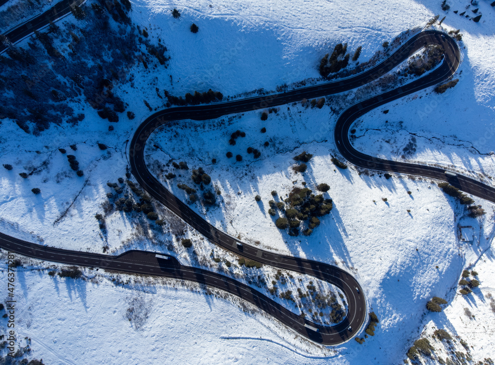Winding road on the mountain in winter seen from above