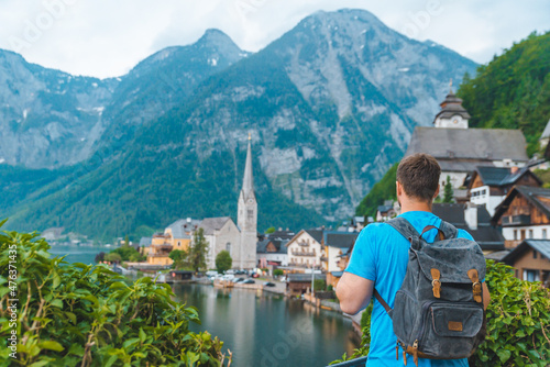 man with backpack looking at hallstatt city
