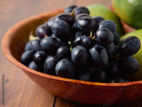 Wallpaper Mural Dark grapes and fresh mango in a small wooden bowl and table. Still life. Light and rich saturated color. Agriculture product Torontodigital.ca