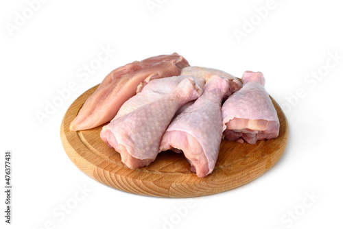 Raw chicken meat: fillet, things and legs on wooden board isolated on white background.