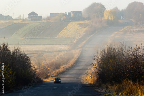 Car on the road in the fog. Autumn landscape